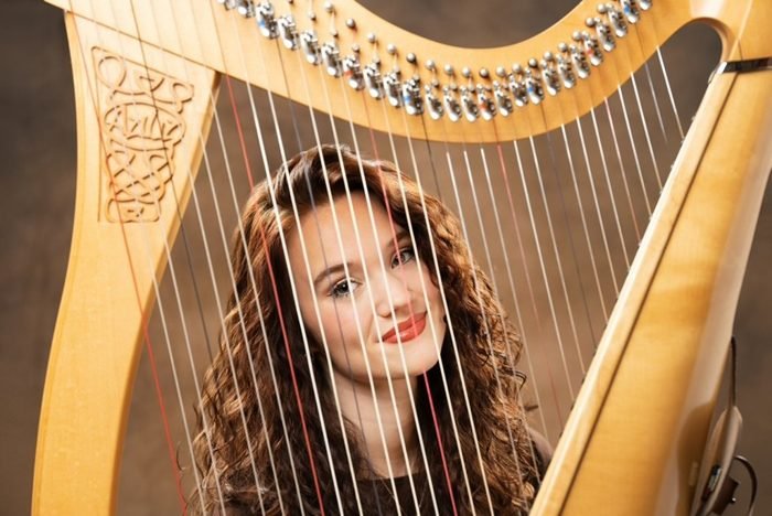 Smiling portrait framed by the harp